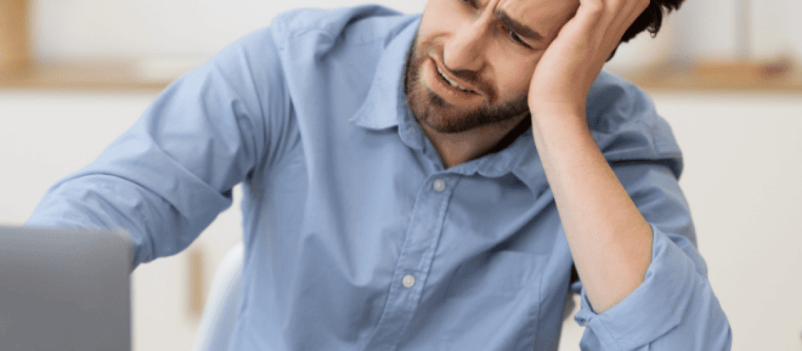 Man sitting at desk despondent